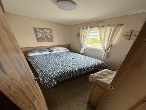 a small bedroom with two beds and a window at Captivating 3-Bed Cabin in Prestonpans in Prestonpans