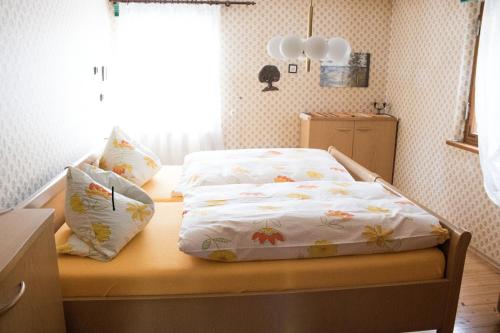 a small bedroom with a bed with flowers on it at Schwabenhof Ferienwohnung II in Leutershausen