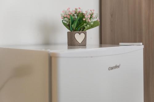 a vase of flowers on top of a refrigerator at Napoli Fly Guest House 290 in Naples