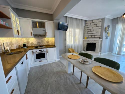 SEAVIEW CASTLE HOUSE في ألانيا: مطبخ مع دواليب بيضاء وطاولة وكراسي