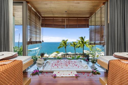 a bedroom with a large bathtub with a view of the ocean at Cape Sienna Phuket Gourmet Hotel & Villas - SHA Extra Plus in Kamala Beach