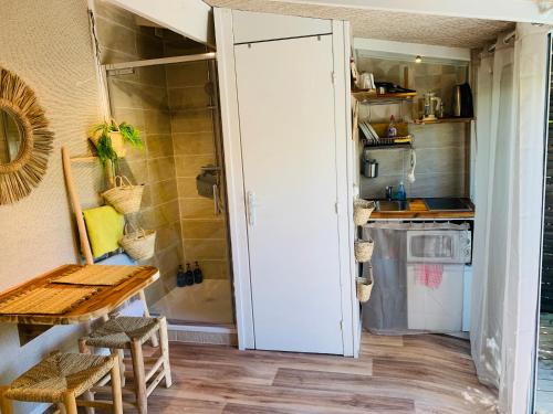una pequeña cocina con mesa y nevera en Studio Gliss'in, en Lacanau-Océan