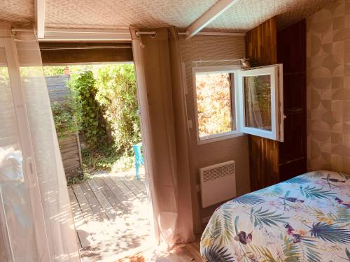 1 dormitorio con 1 cama y puerta corredera de cristal en Studio Gliss'in, en Lacanau-Océan