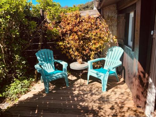 dos sillas azules y una mesa en un porche en Studio Gliss'in, en Lacanau-Océan