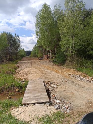 uma ponte de madeira numa estrada de terra com árvores em Czyli Chill em Nisko