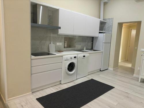 a kitchen with white cabinets and a washing machine at Appartamento Albert in Livorno