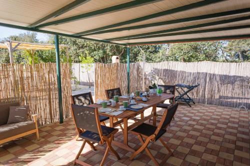 Une table et des chaises en bois sont disponibles sur la terrasse. dans l'établissement Bungalow Felicità 1 with Pool - Happy Rentals, à San Cassiano