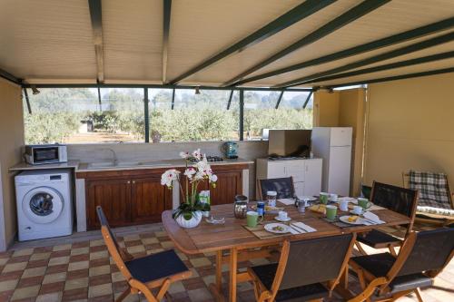 Il dispose d'une cuisine et d'une table à manger avec des chaises. dans l'établissement Bungalow Felicità 1 with Pool - Happy Rentals, à San Cassiano