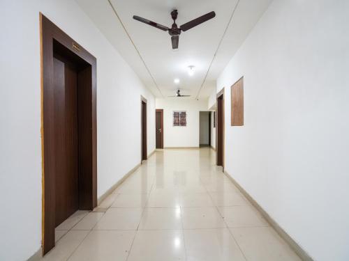 einen Korridor mit weißen Wänden und einer Decke in der Unterkunft OYO Tathastu Inn in Raipur