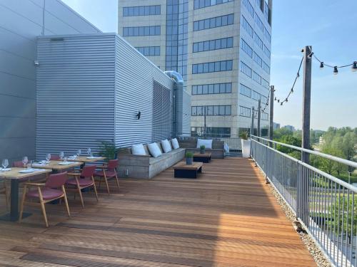 une terrasse avec des tables et des chaises dans un bâtiment dans l'établissement Cityden Zuidas, à Amstelveen
