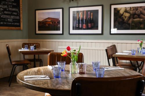 a table in a restaurant with a vase of flowers on it at The Swan at Forest Row in Forest Row