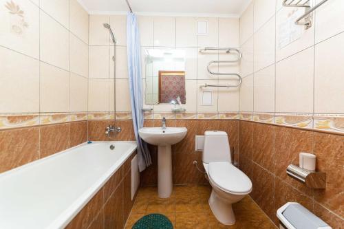 uma casa de banho com um WC, um lavatório e uma banheira em O Azamat em Astana