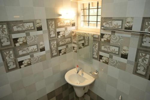 La salle de bains est pourvue de toilettes et d'un lavabo. dans l'établissement The White Bloom 3BHK, à Munnar