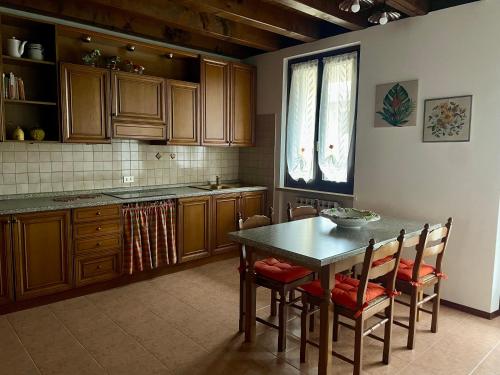 une cuisine avec une table et des chaises ainsi qu'une fenêtre dans l'établissement CASA GIULIA, à Monzambano