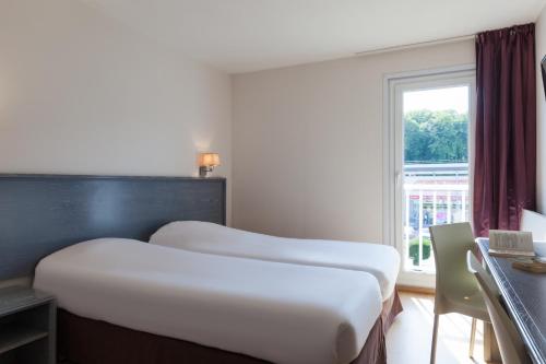アンデルナンにあるThe Originals City, Hôtel Le Louisiane, Belfort Sudの窓付きのホテルの部屋にベッドが2つある
