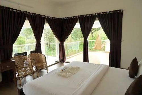 um quarto com uma cama e uma grande janela em The White Bloom 3BHK em Munnar