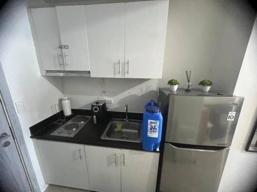 a small kitchen with a sink and a refrigerator at 39th Flr Condo Unit with View in Manila