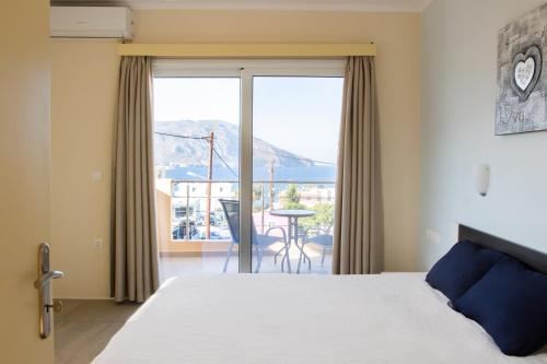 Schlafzimmer mit einem Bett und Blick auf einen Balkon in der Unterkunft Sun and Sea in Karpathos