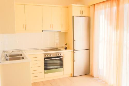 eine Küche mit weißen Schränken und einem Kühlschrank in der Unterkunft Sun and Sea in Karpathos