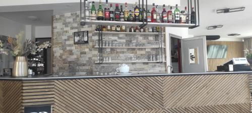 a bar with alcohol bottles on a brick wall at Albergo Da Bittu in Samughèo