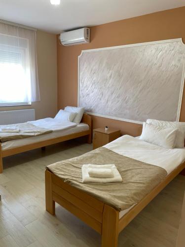 een kamer met 2 bedden en een raam bij Sobe Sara in Šabac