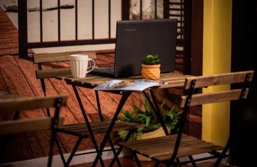 - une table avec un ordinateur portable et une tasse sur une terrasse couverte dans l'établissement SuiteSicily Rooms Vasca Idromassaggio Palermo, à Altavilla Milicia