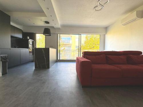 馬賽的住宿－Appartement T3 72 m²，一间带红色沙发的客厅和一间厨房