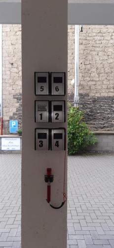 a pole with four signs on the side of a building at Gästehaus Am Hochsimmer in Ettringen