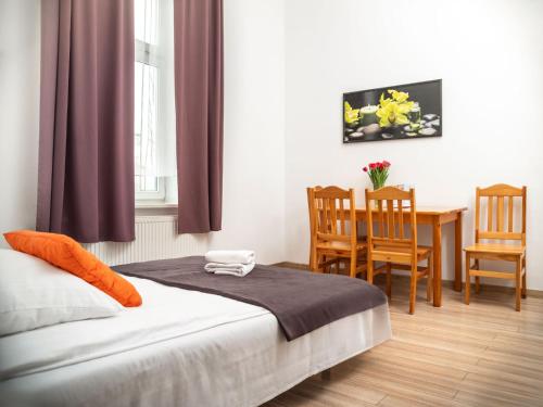 1 dormitorio con 1 cama, mesa y sillas en Station Aparthotel, en Cracovia