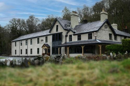 a large white house with a roof at Tyn-y-Coed Inn in Betws-y-coed