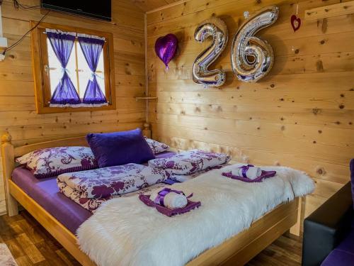 a log cabin with a bed with a number at Cottage La Sierra with JACUZZI in Korenica