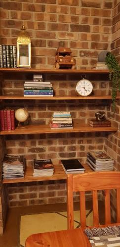 a brick wall with a desk and a clock at Walkersons Trout and Nature Haven in Dullstroom
