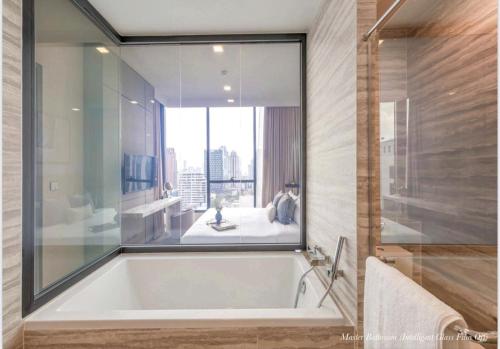 La salle de bains est pourvue d'une baignoire et d'une grande fenêtre. dans l'établissement 位于市中心的豪华 2 床 2 浴室可入住 4 名阿索娜娜 (Asok Nana), à Bangkok