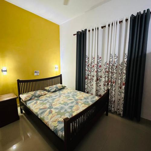 ein Schlafzimmer mit einem Bett in einem Zimmer mit Vorhängen in der Unterkunft Villa Sara in Aluthgama