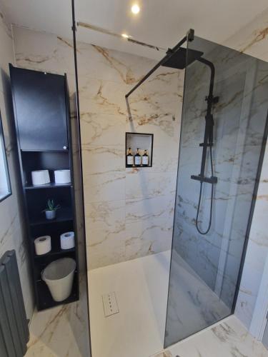 y baño con ducha y pared de mármol. en Modern Detached 3 bedroom home with off-road parking & bike store en Abercanaid