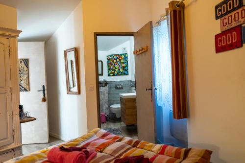 a bedroom with a bed and a bathroom at Le Moulin de Pascale in Espelette