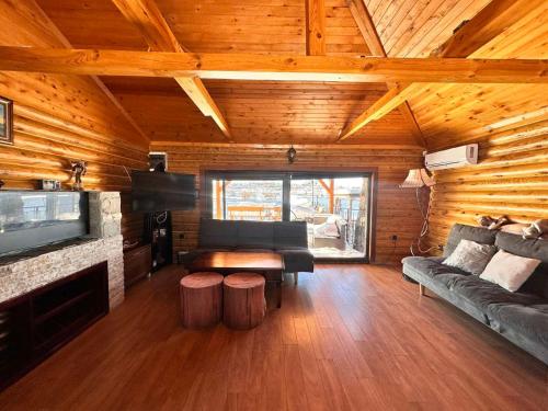 ein Wohnzimmer mit einem Sofa und einem TV in einer Hütte in der Unterkunft Къща за Гости in Ivanyane