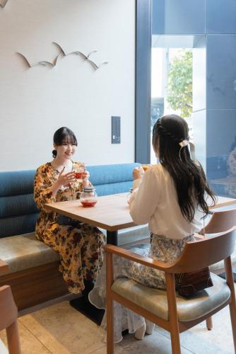 two women sitting at a table in a restaurant at The Royal Park Canvas - Kobe Sannomiya in Kobe