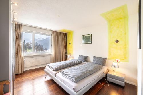 a bedroom with a bed and a large window at Feriensiedlung Trü 2 in Scuol