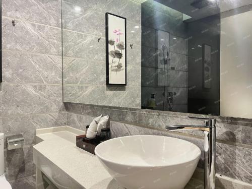 a bathroom with a white sink and a mirror at Paco Hotel Tiyuxilu Metro Guangzhou-Free Shuttle Bus during Canton Fair&5 Min walk to Canton Fair Buyer Registration Store in Guangzhou