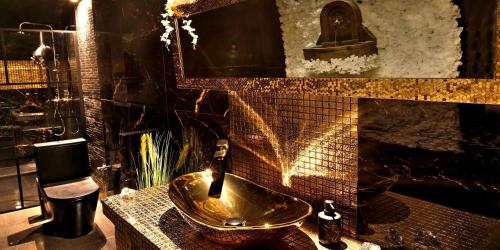 a bathroom with a copper sink and a fireplace at Ferrari wellness apartmán in Pardubice