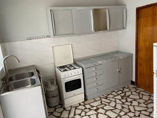 a small kitchen with a stove and a sink at 3 Bedroom Villa with Garden in Addis Ababa Bole in Addis Ababa