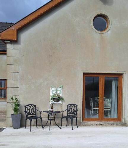 a patio with three chairs and a table and a table and a table at SANDYS SHORE APARTMENT in Donegal