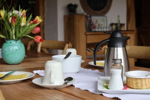 a table with a tea kettle and dishes on it at Hotel Carolaruh in Bad Elster