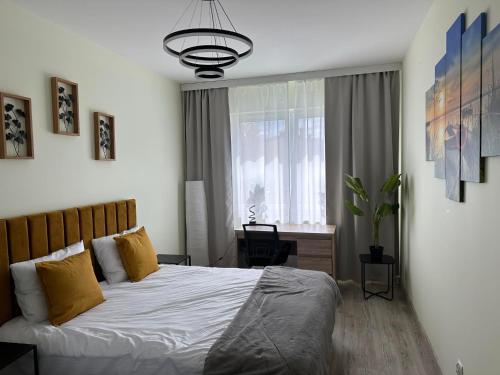 a bedroom with a bed and a desk and a window at Warmia Loft Apartament nad Iławką in Iława