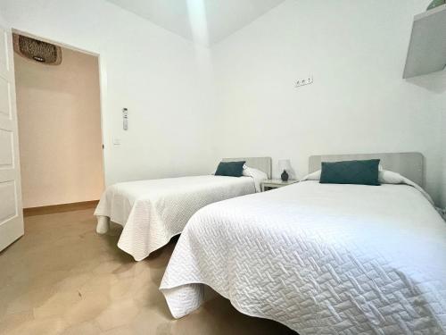 two beds with white sheets in a room at Descanso en el Corazón: Córdoba in Córdoba