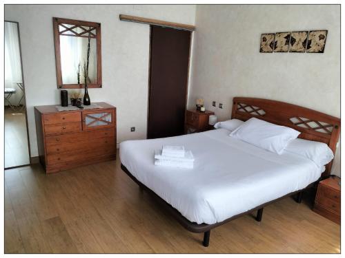 een slaapkamer met een bed, een dressoir en een spiegel bij Magnífico Alojamiento en el centro in Valdepeñas