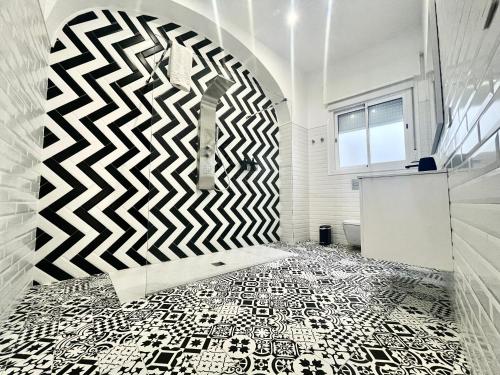 a bathroom with a black and white patterned floor at Descanso en el Corazón: Córdoba in Córdoba