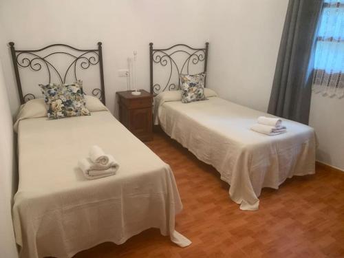 a room with two beds with towels on them at Apartamentos La Mina de Viñón. in Santa Eulalia