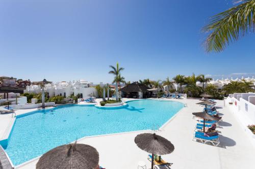 a view of a swimming pool with umbrellas and the ocean at Paradise Homes Tenerife in Playa Paraiso